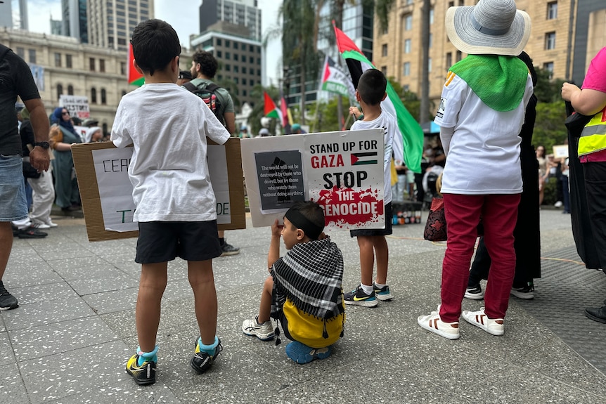 three young children photographed from behind at a rally