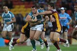 Tight contest ... Tim Grant tries to break the Broncos' defence