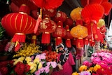 A woman wearing a face mask walks under Chinese New Year lantern decorations