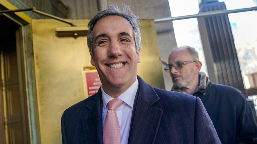 Donald Trump's former lawyer and fixer Michael Cohen smiles as he arrives for a second day of testimony before a grand jury.