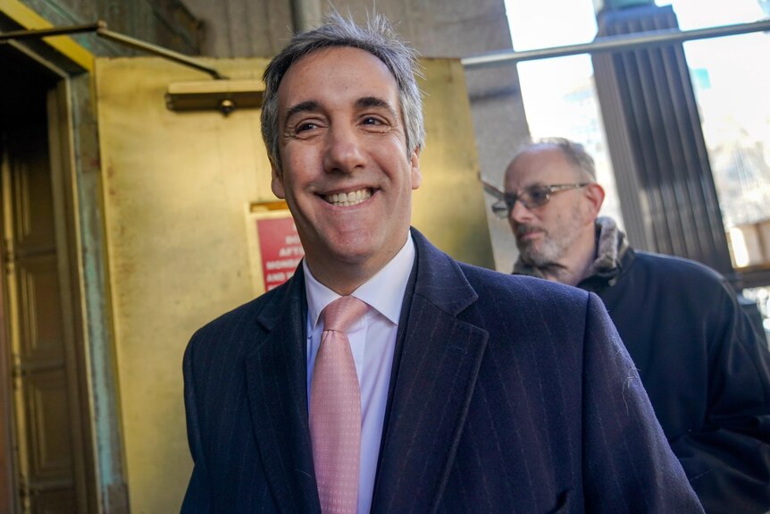 Donald Trump's former lawyer and fixer Michael Cohen smiles as he arrives for a second day of testimony before a grand jury.