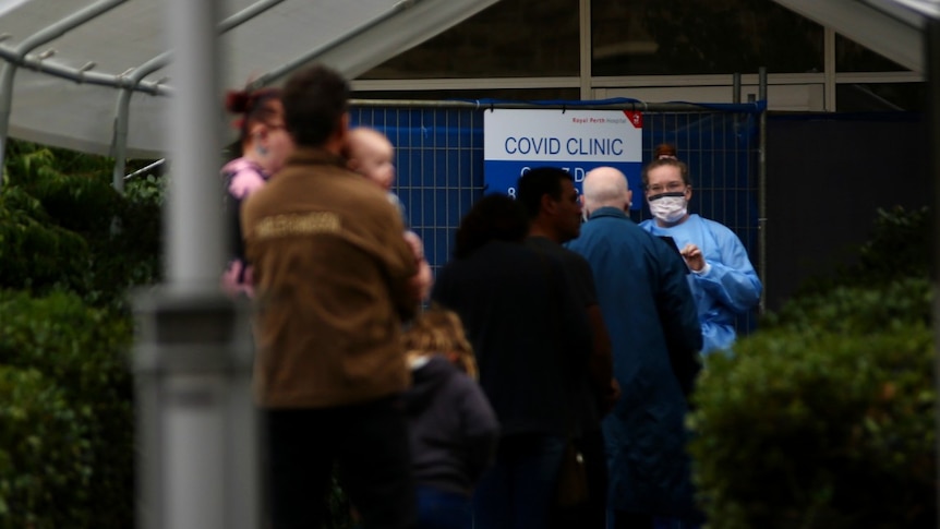 People queue to see COVID clinic health worker