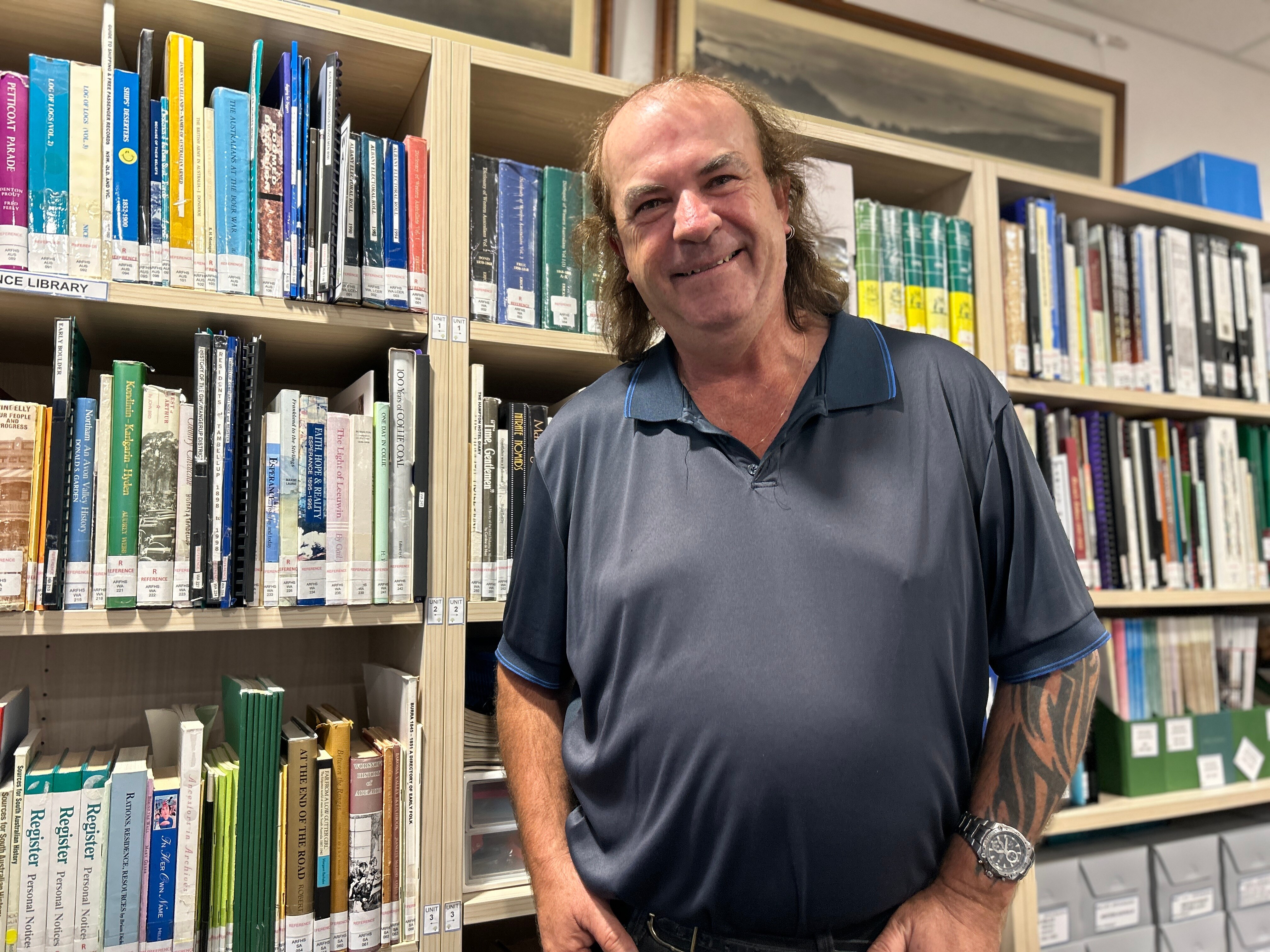 Man stands in front of bookcase