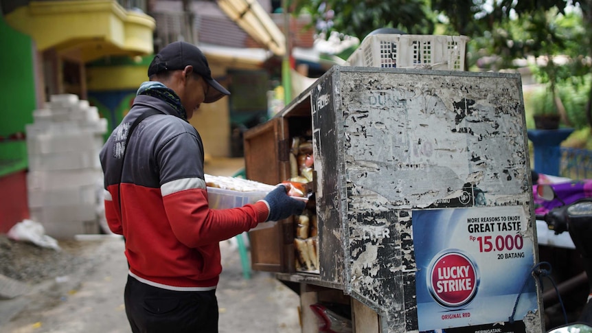 An advertisements for "great taste" cigarettes is plastered onto the side of a street vendor's bread van