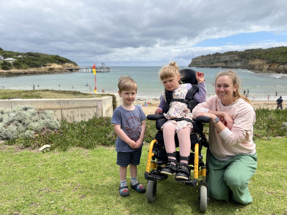 A small family at the beach, a young child is in a wheelchair