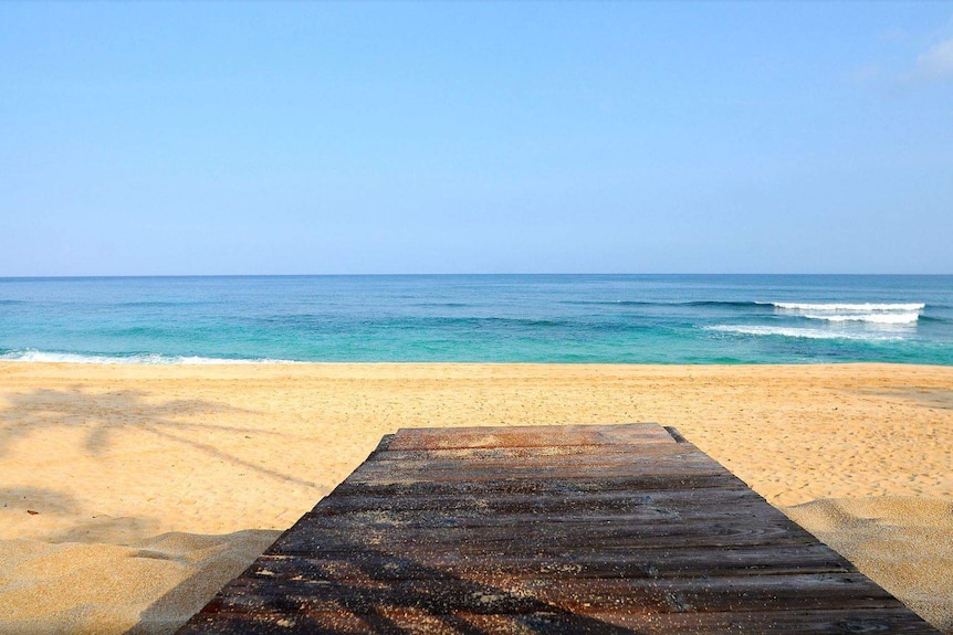 A board leads onto a beach.