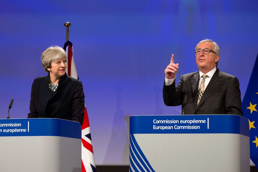 Former British Prime Minister Theresa May, left, stands next to European Commission President Jean-Claude Juncker