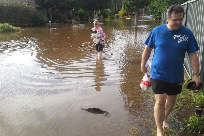 Residents wade through water