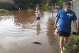 Residents wade through water