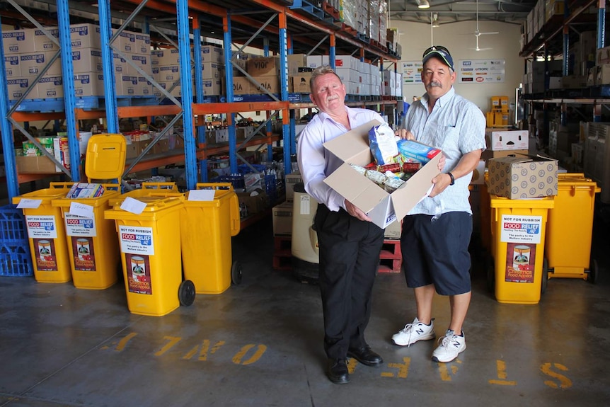 Food Relief NQ's Toby Kelly hands a box to Michael Stainbrook of the Northreach Baptist Church