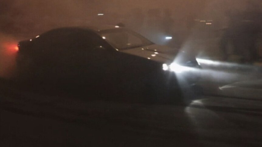 A car does burnouts on the road