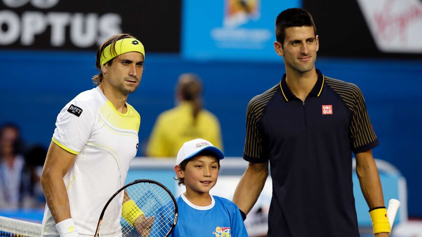 David Ferrer and Novak Djokovic pose for a photo with a boy before a tennis match.