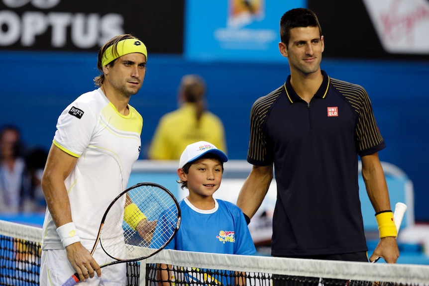 David Ferrer and Novak Djokovic pose for a photo with a boy before a tennis match.