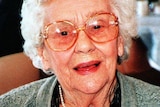 Headshot of smiling grey-haired woman.