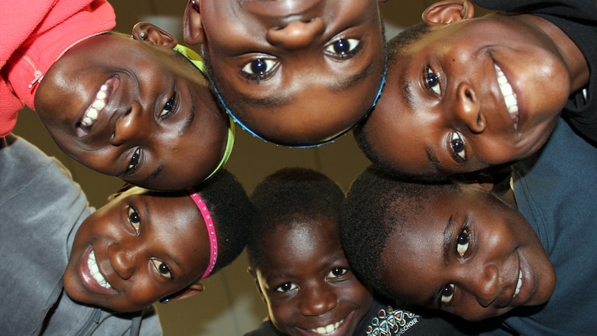 The African Children's Choir visited an AFL match and learnt the Collingwood song so they could get amongst the action.