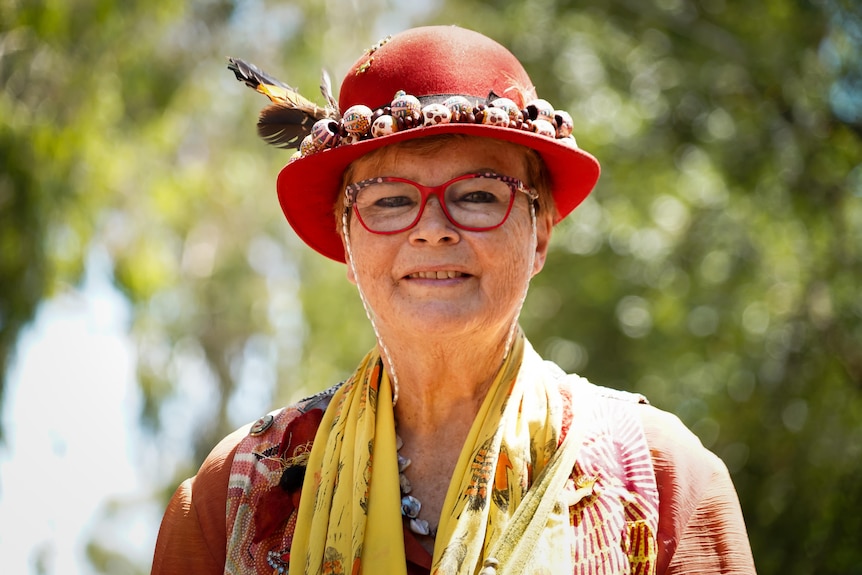 A woman in a bright outfit and hat