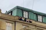 People hide on the roof of a building.  