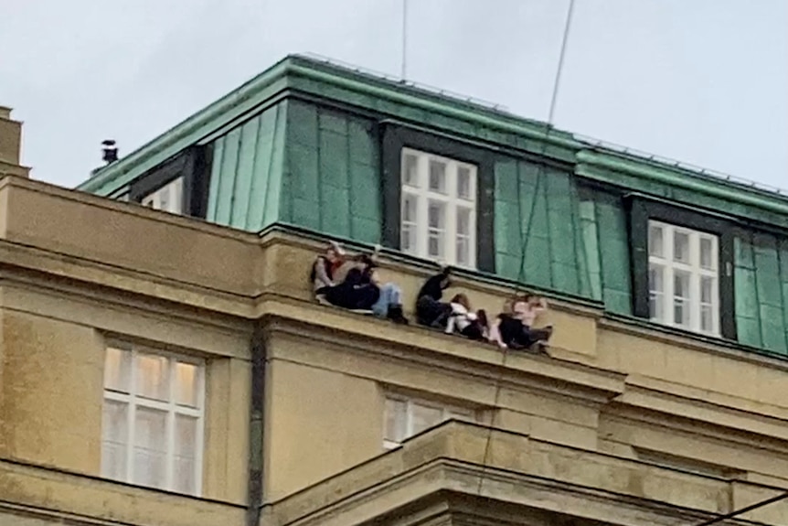 People hide on the roof of a building.  