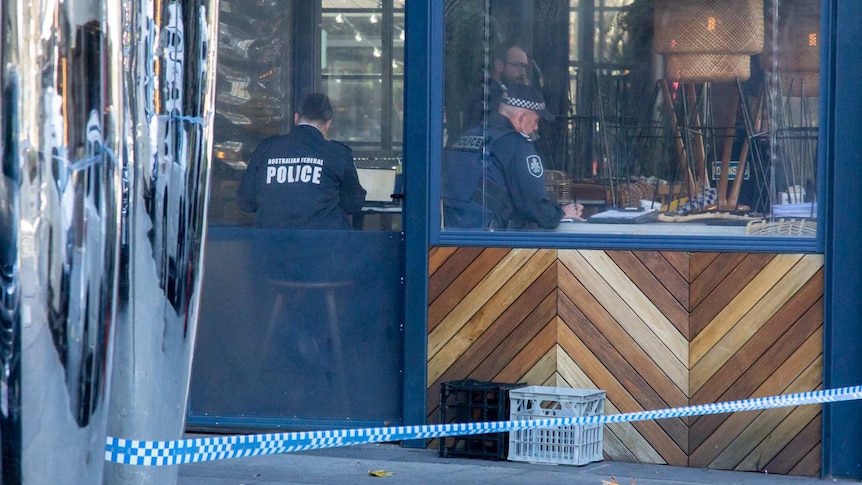 Law enforcement officers investigate a bar crime scene.