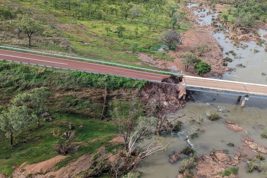 Aerial photo of damaged bridge missing a huge chunk and 4wd