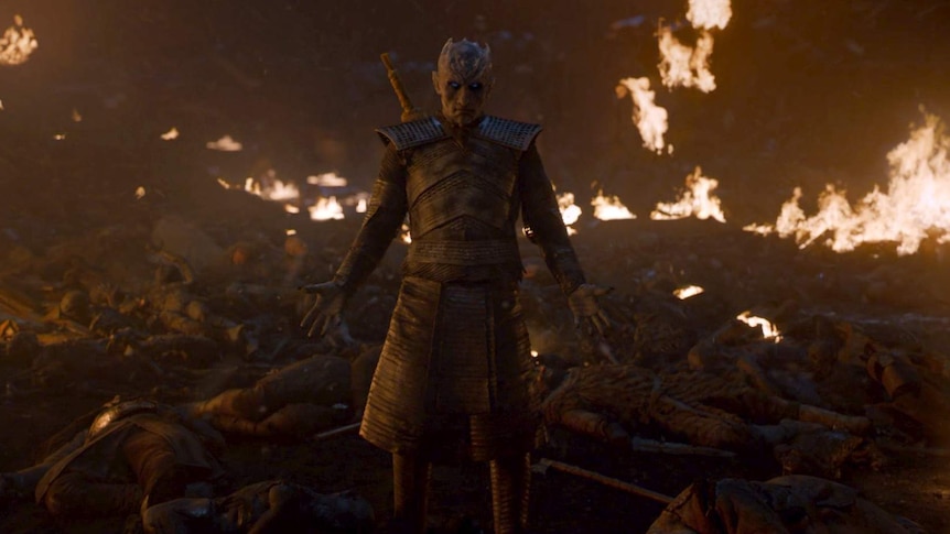The Night King stands among dead bodies outside the walls of Winterfell and raises his hands slowly to wake the dead.