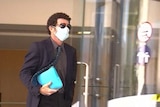 Justin Millington wearing sunglasses and a mask. 