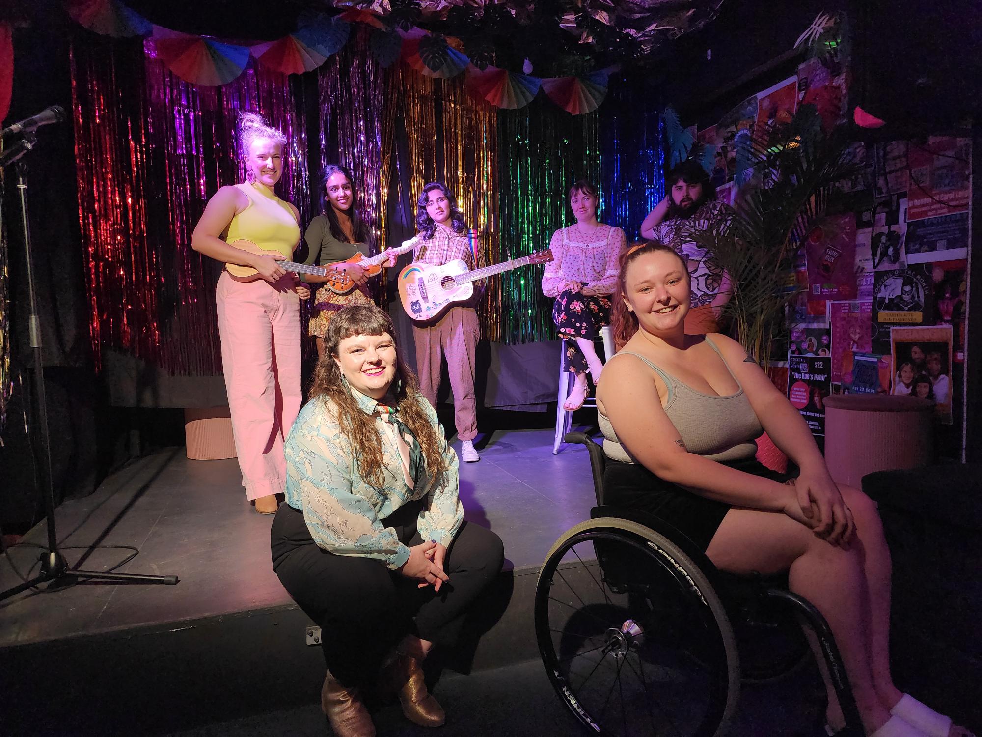 A group of performers on stage in a bar
