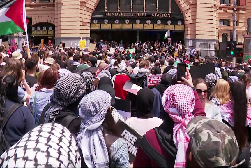 A crowd of people take part in a pro-Palestinian protest outside Flinders Street.