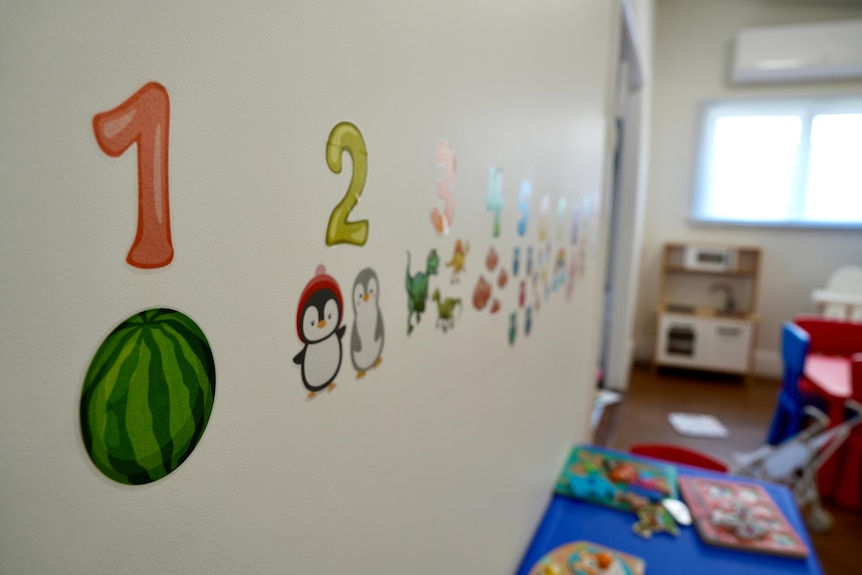 A watermelon stickered to a wall with the number 1 about it at a children's daycare. 