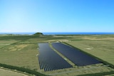 solar farm on open land with ocean in the horizon
