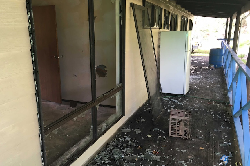 The veranda of the home showing 12 windows smashed on one side of the building