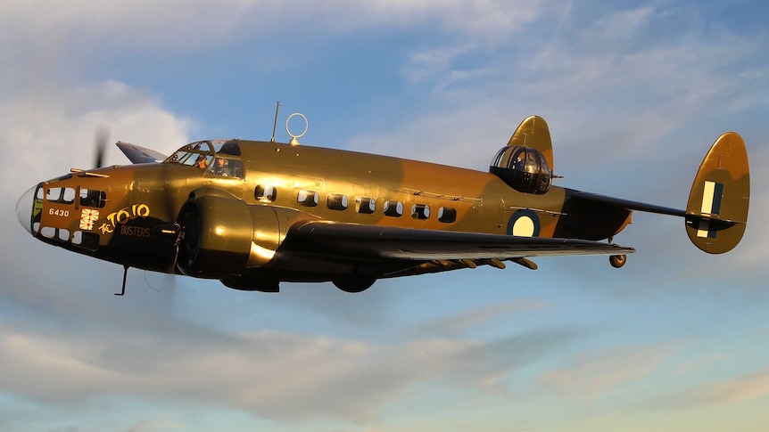 Picture of an old plane from the 1940s flying in the sky.