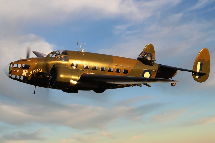 Picture of an old plane from the 1940s flying in the sky.