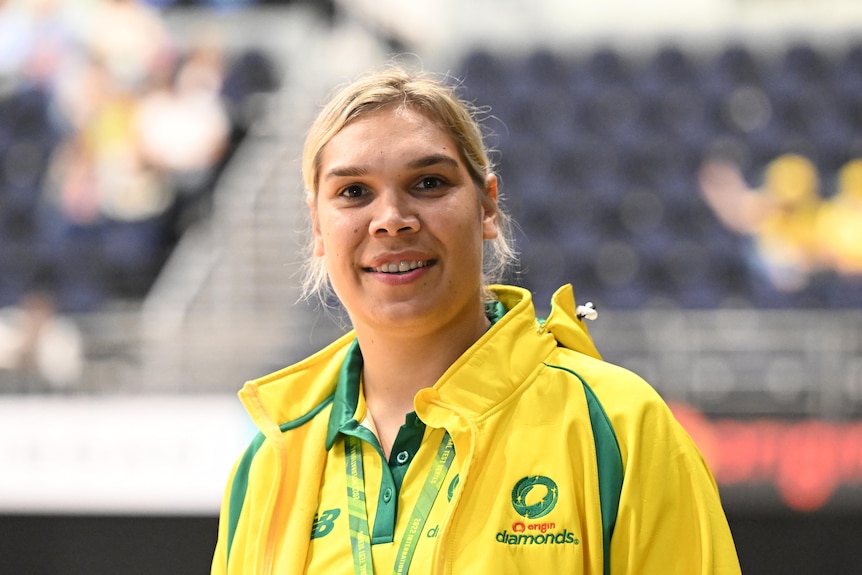 Donnell Wallam looks at the camera and shares a relaxed smile in her green and gold Diamonds tracksuit