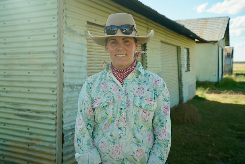 Woman in hat and sunglasses staring at camera