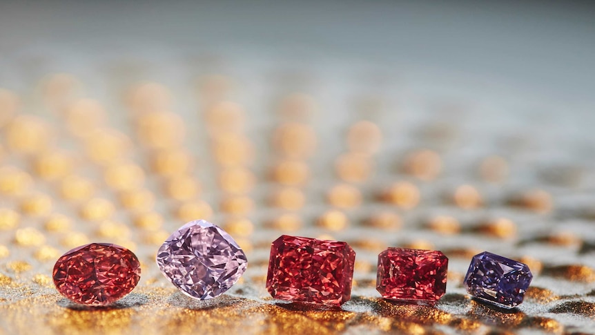 Five red, pink and purple diamonds on display.