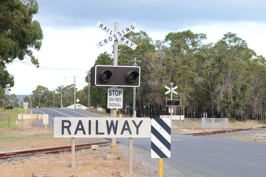 A disused railway crossing with lights and a 'railway' sign.