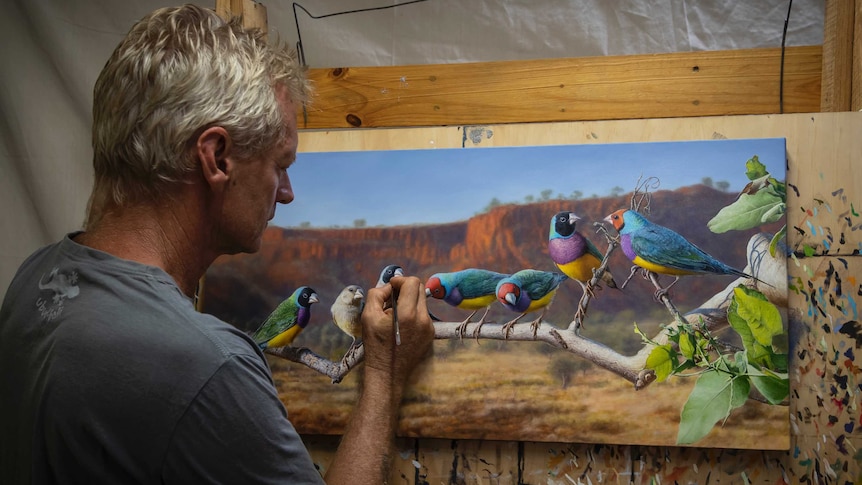 Man painting a picture of birds on a branch