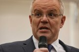 Prime Minister Scott Morrison speaks into a microphone at a campaign event during the federal election.