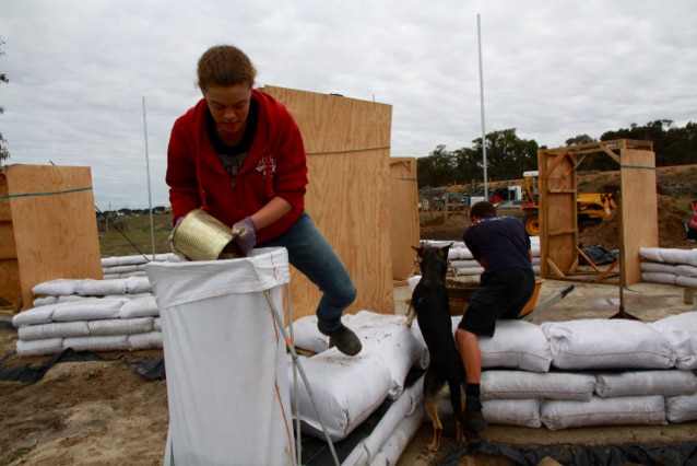 A volunteer helps fill an earth bag in Kendenup, WA