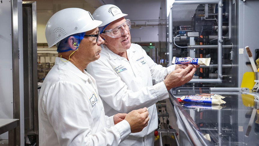 Scientists in a factory holding a chocolate bar