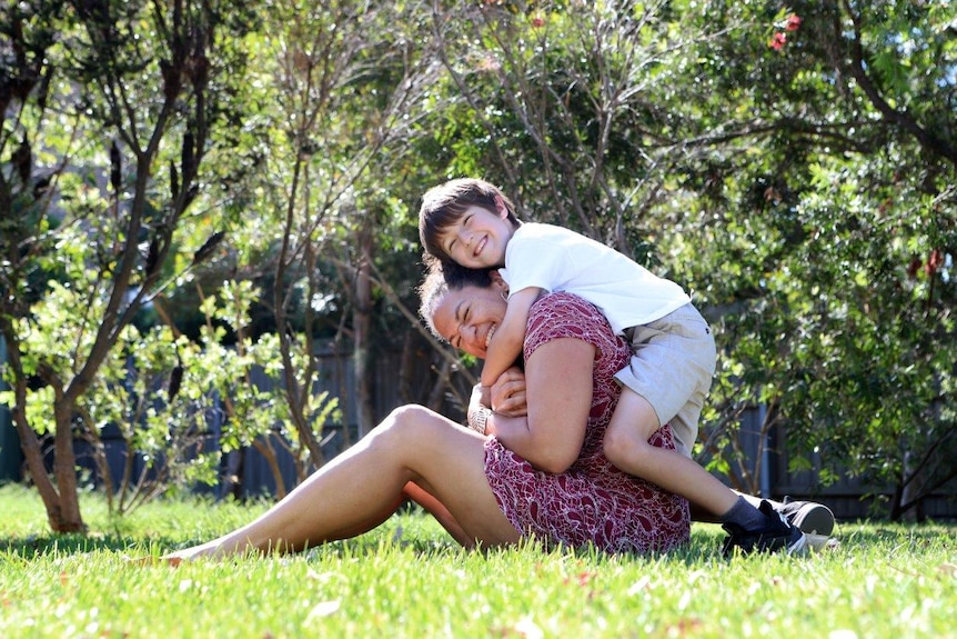 A mother and child play in the park