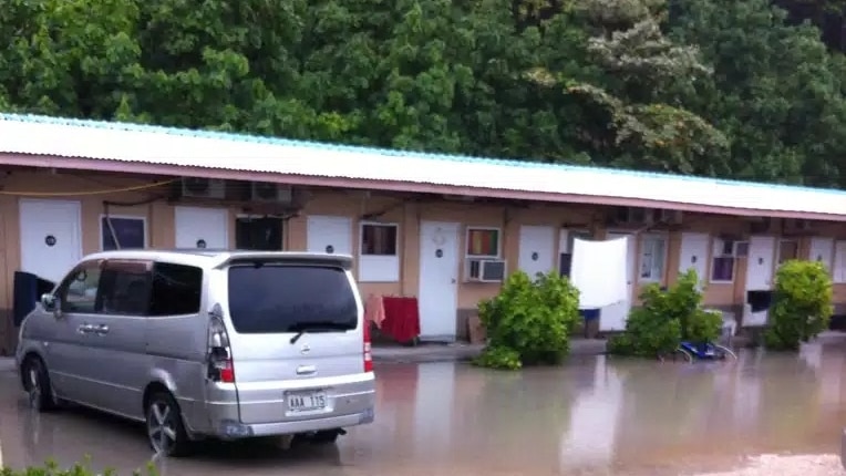 Anibare Lodge on Nauru. It is a series of 30 bed sit units. In this image, the car park area has been flooded after rain.