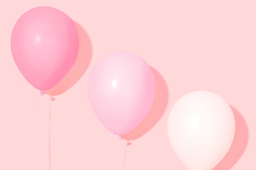 Hands holding pink balloons