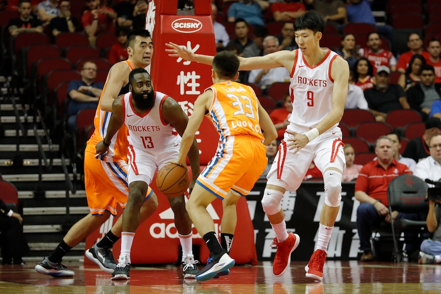 Zhou Qi playing with the Houston Rockets in the NBA next to James Harden.