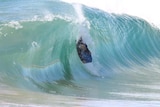 A bodyboarder pulls into a thick, hollow wedge of water.