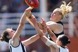 Tayla Harris and two Collingwood players, including Stacey Livingstone, compete for an aerial ball