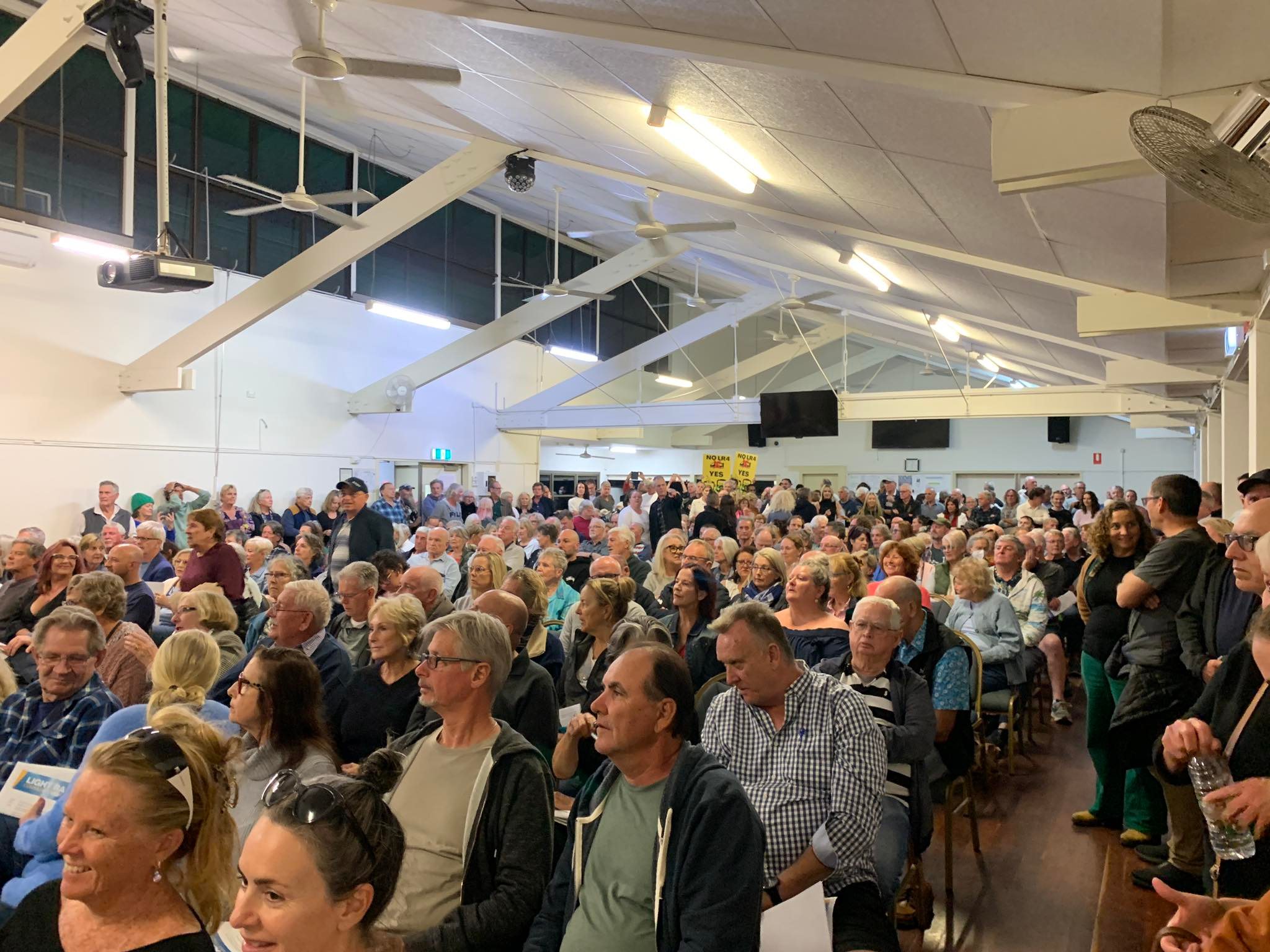 A group of people seated at a town hall meeting.
