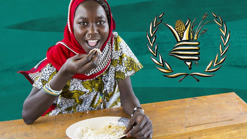 A girl from Africa sits at a table eating.