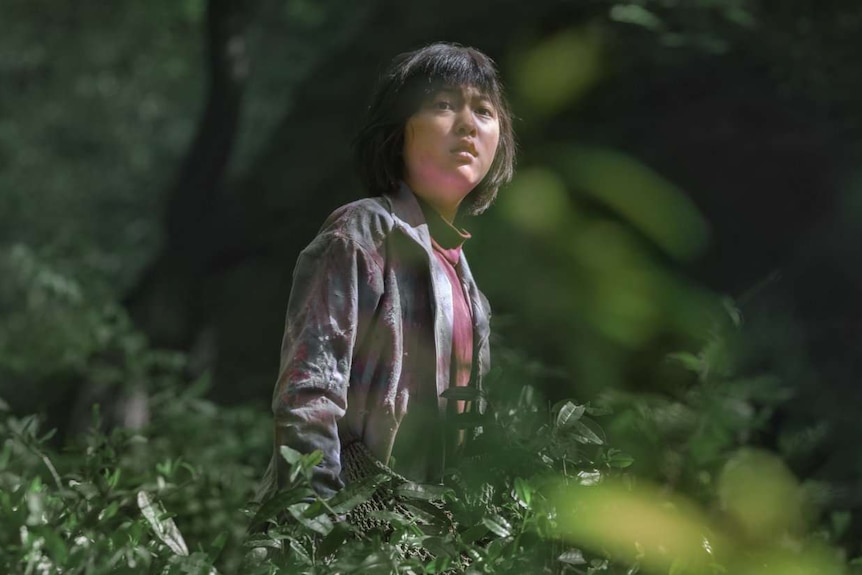 Colour photograph of South Korean actress Ahn Seo-hyun standing amongst trees.